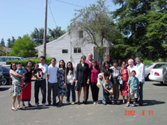 Members of the church with Pastor Bernardo on left.  Parsonage in Background.  Photo taken 8-11-02